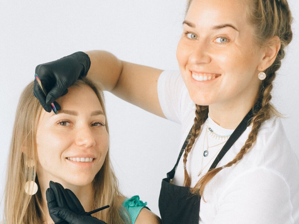 Girls smiling while doing eye lash extensions in Toronto