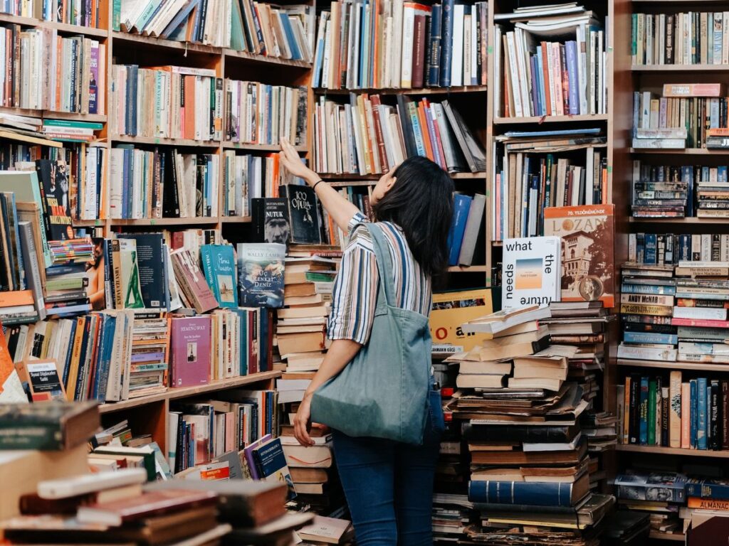 woman choosing book from a haphazard library