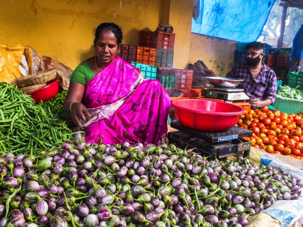 lady selling vegetables in a farmers market
