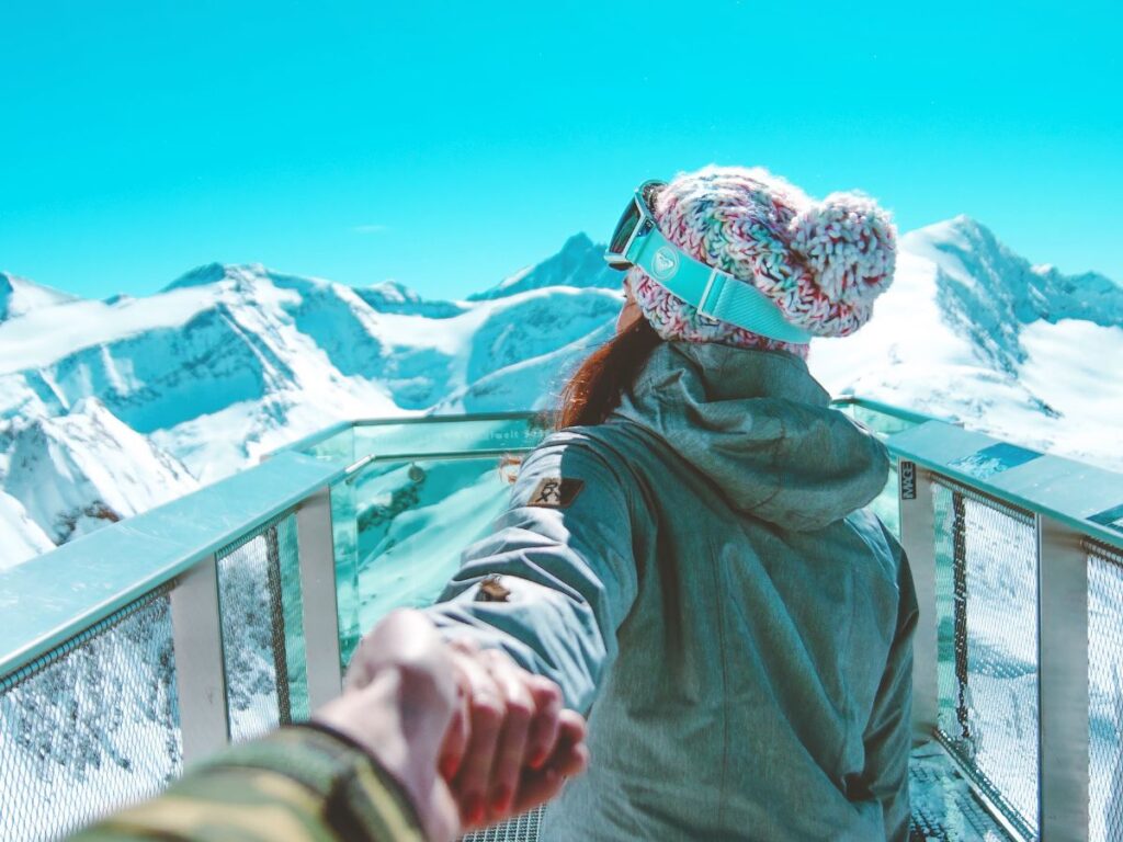 woman holding hand of a man in a ski resort