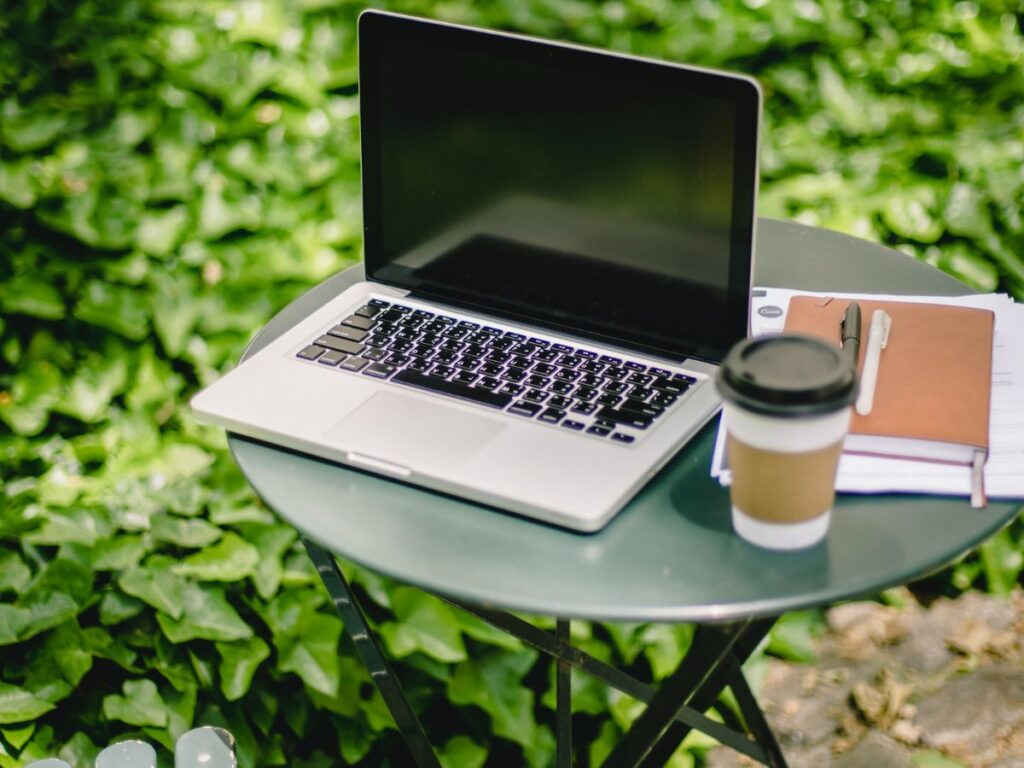 laptop and coffee on a table in outside cafe