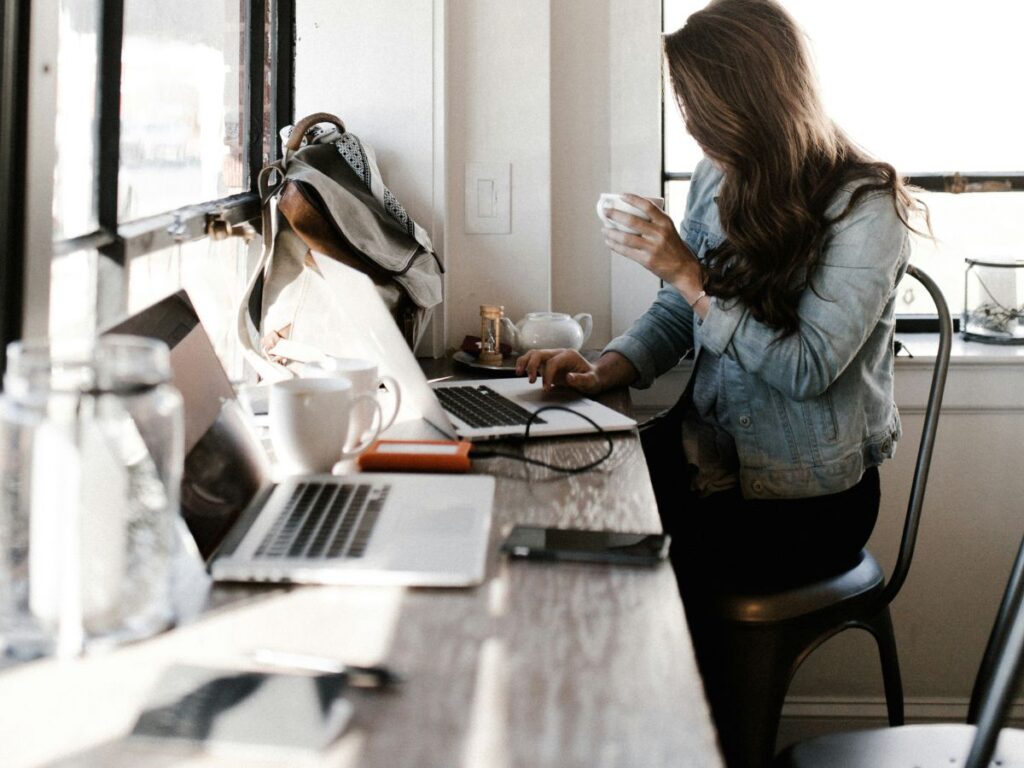 woman drinking coffee and working in a study cafe