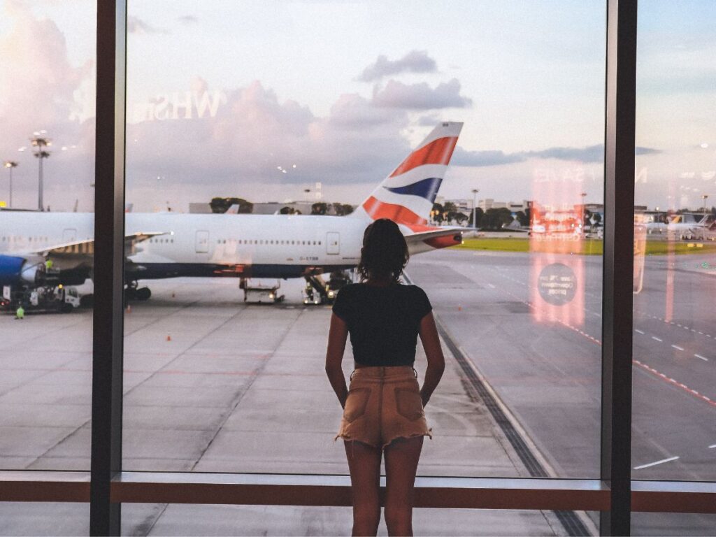 woman looking at aeroplane and runway at airport
