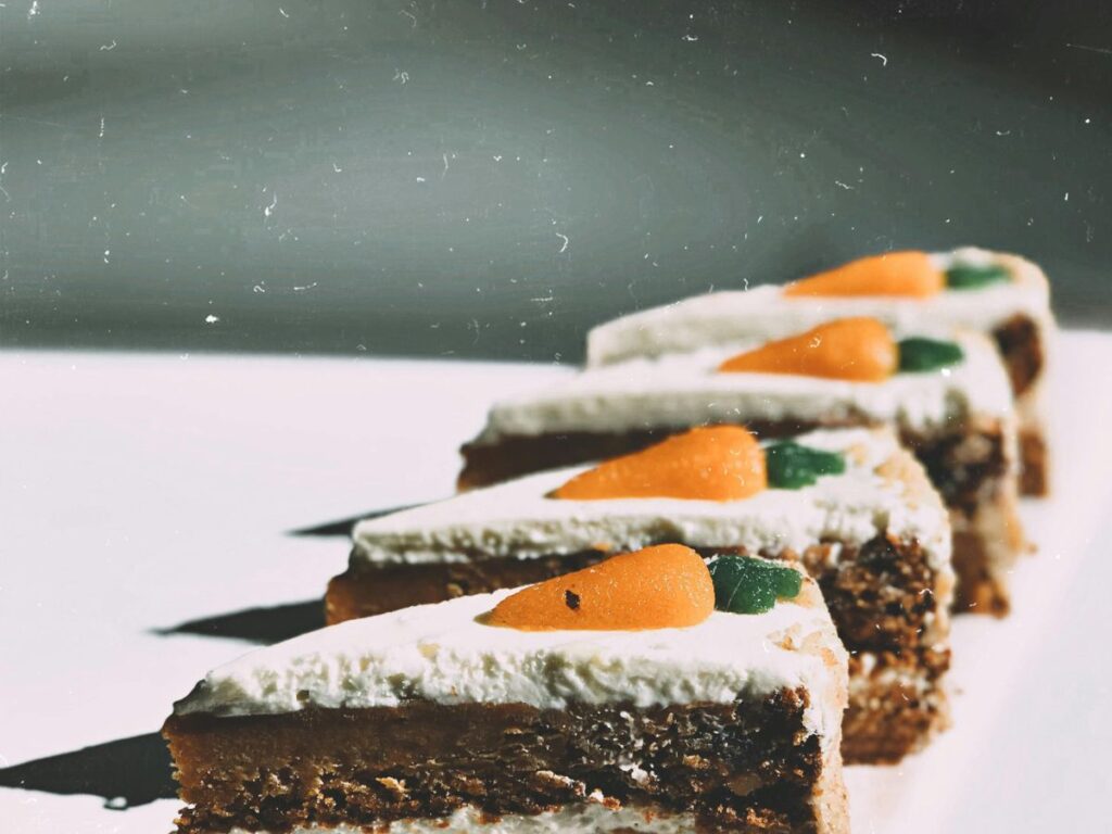 slices of carrot cake with carrot on top