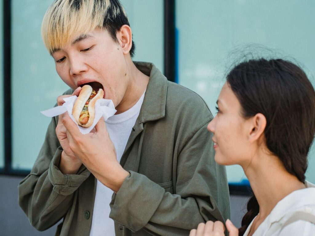 Korean eating a roadside burger