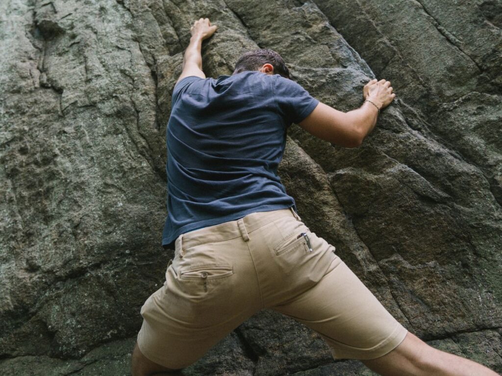 man climbing a rock