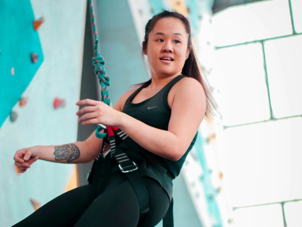 woman wearing belt in a rock climbing gym
