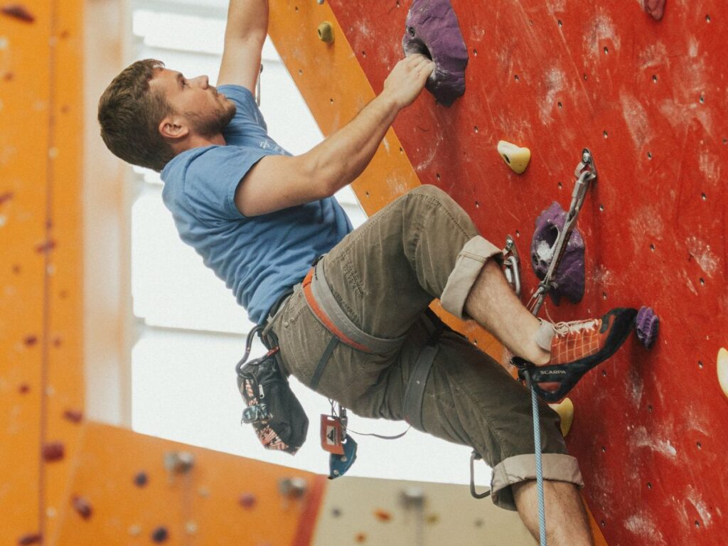 man climbing the rock climbing gym
