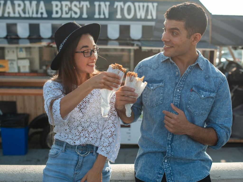 man and woman eating shawarma