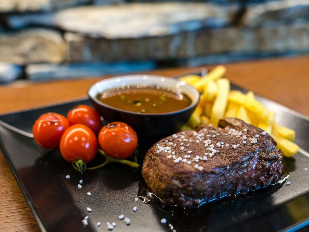 steak served with sauce and fries