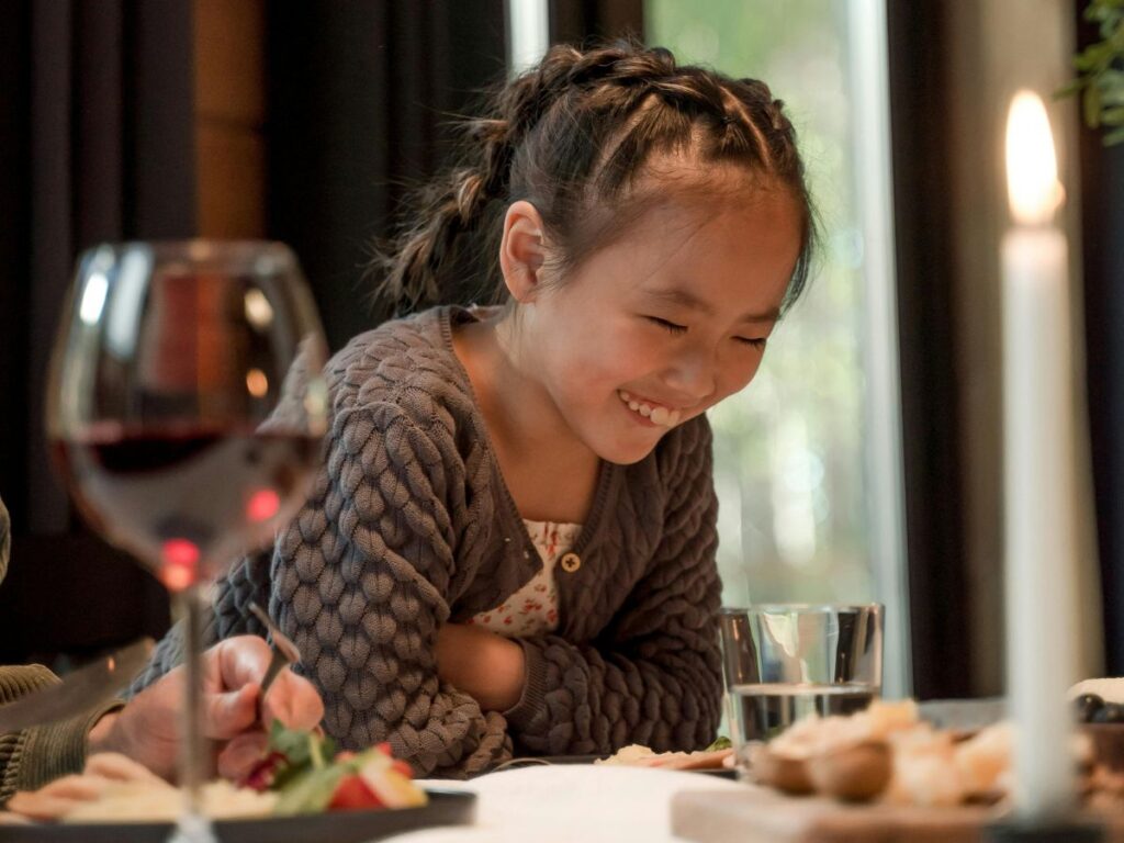 little girl laughing in a restaurant
