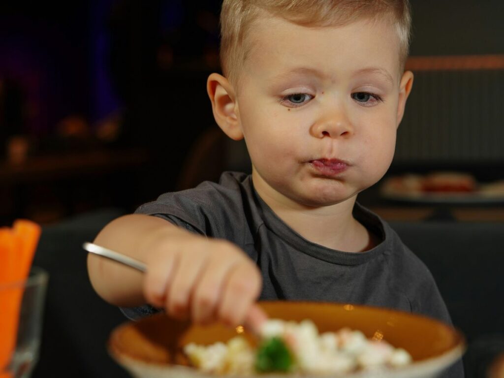 young boy eating his food 