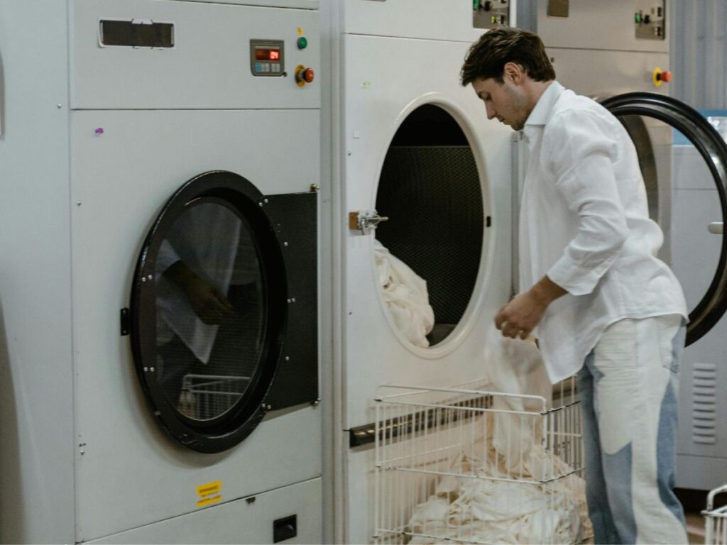 man putting his clothes in washing machine