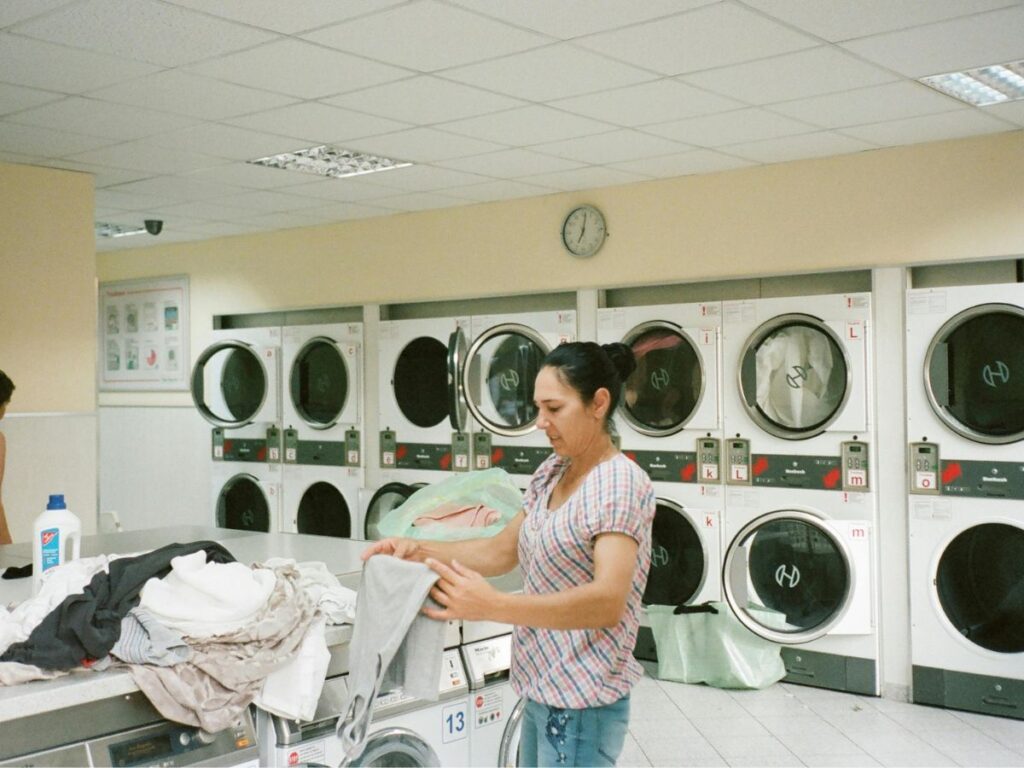 woman folding clothes in laundromat