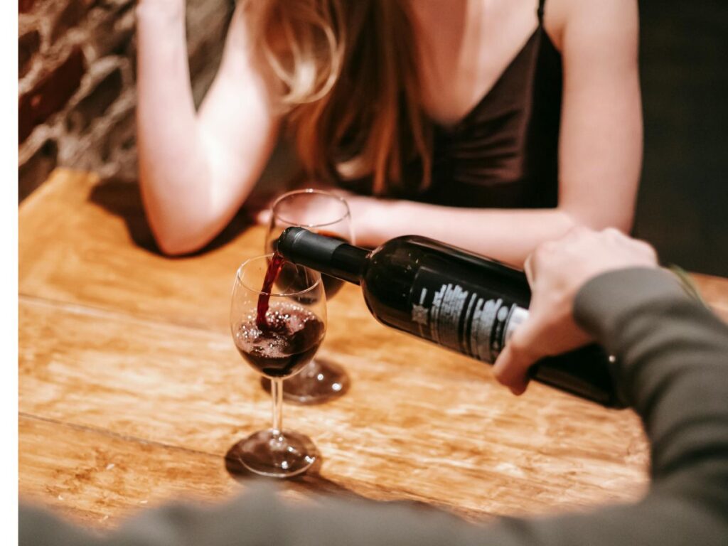 man pouring a drink for lady