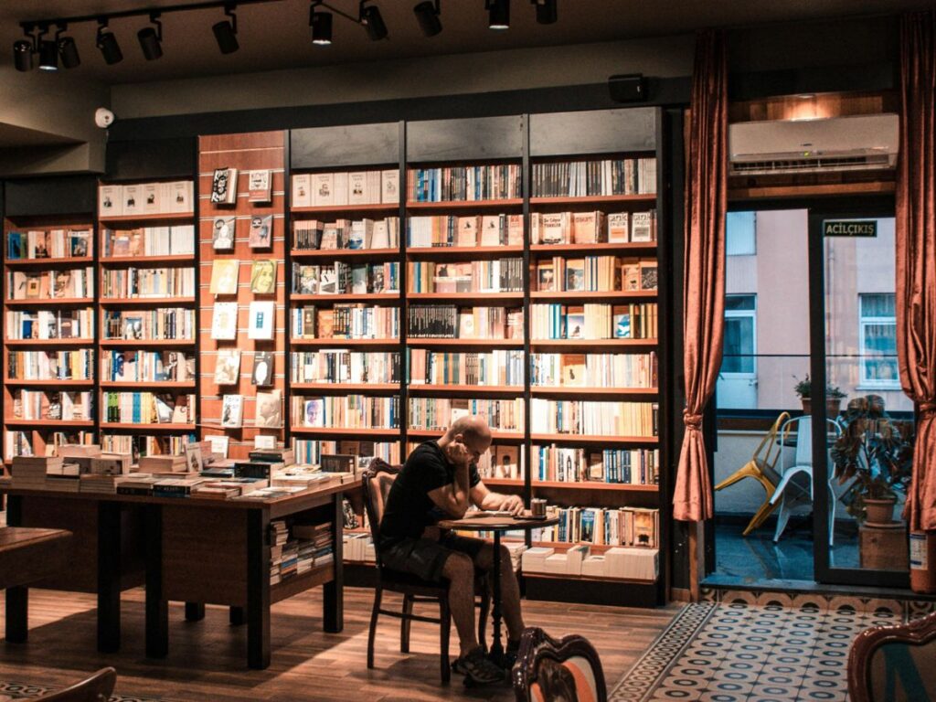 man reading book in a cafe