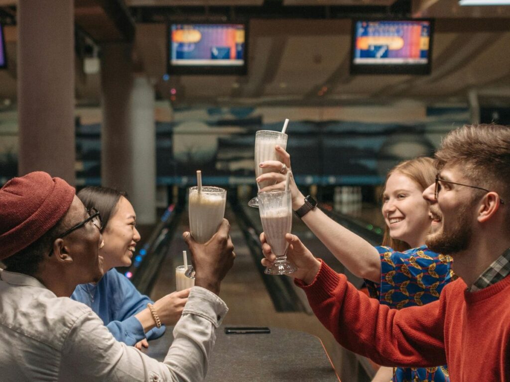 friends drinking milkshake at a bowling alley