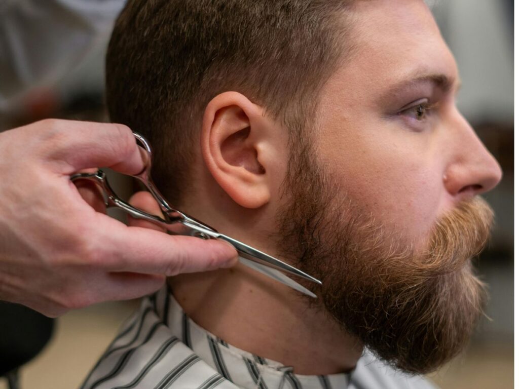 man getting his beard trimmed
