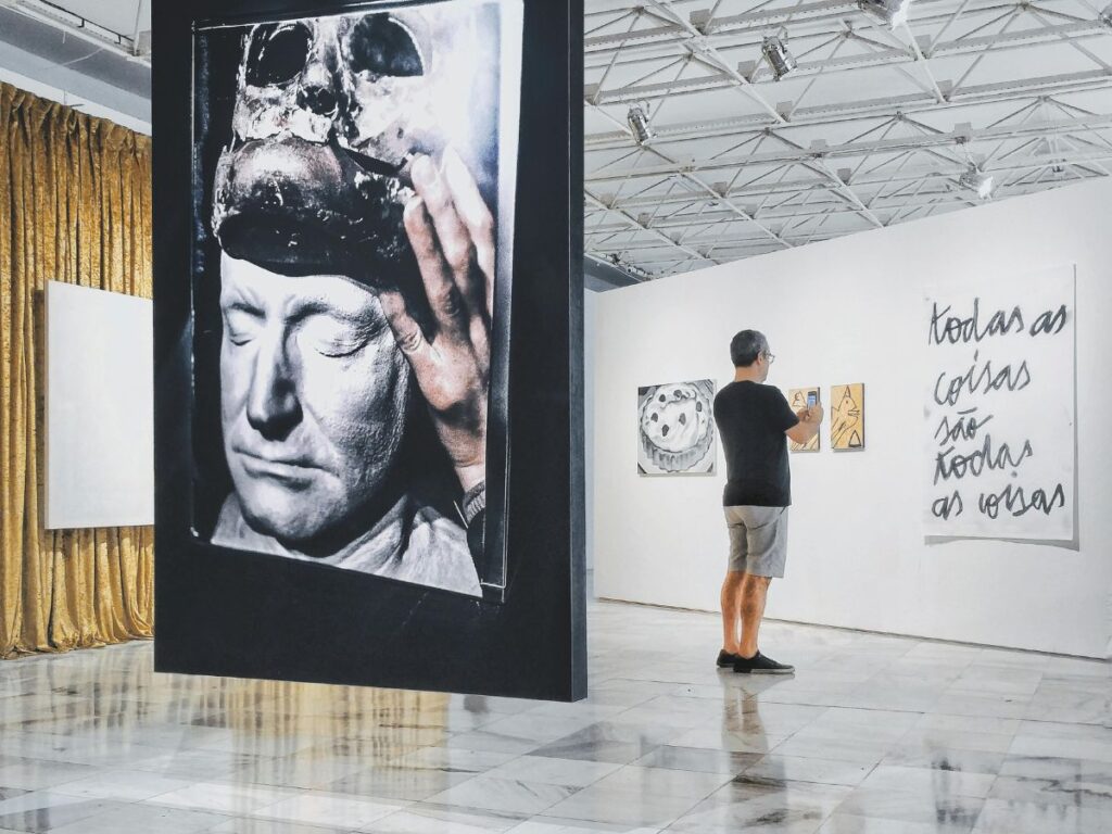 man watching art in a gallery