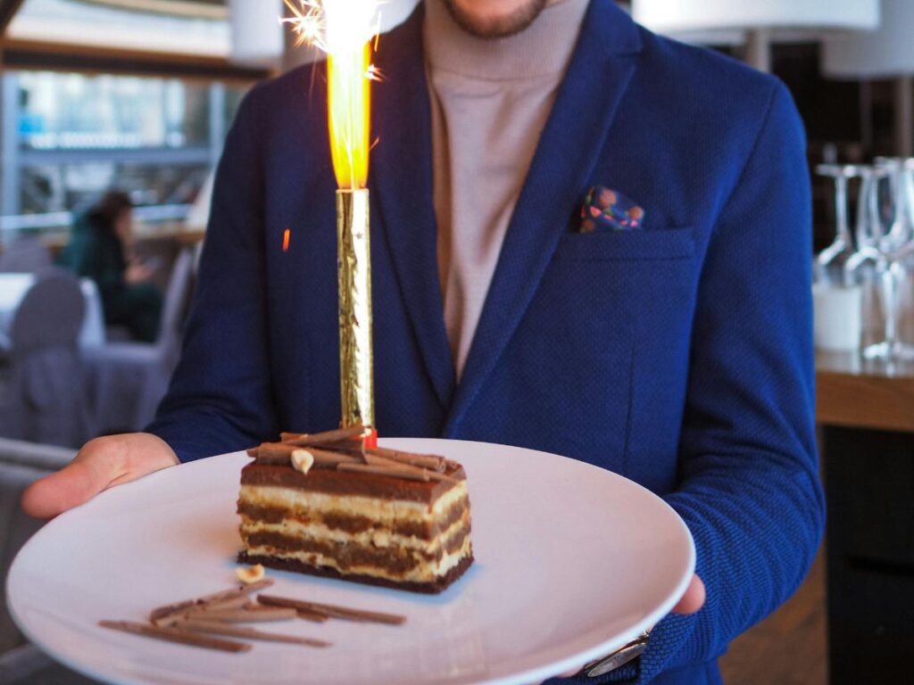 waiter bringing cake with candle