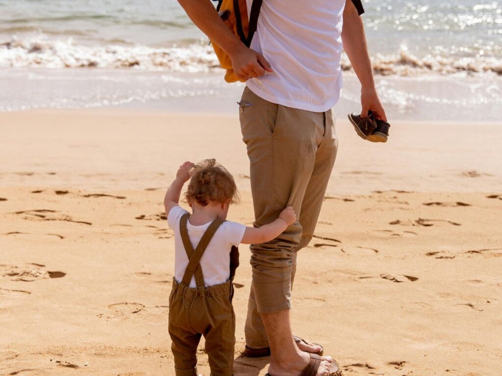 kid with his dad on a beach