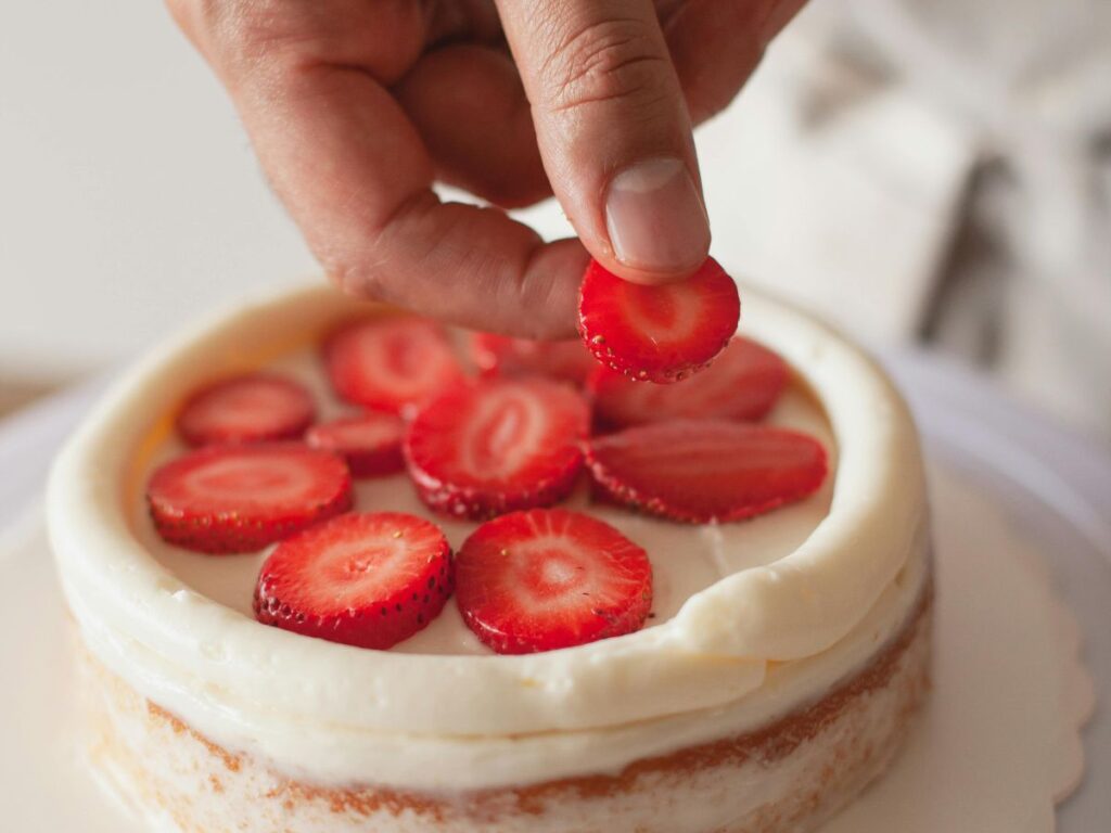 adding strawberries to dessert