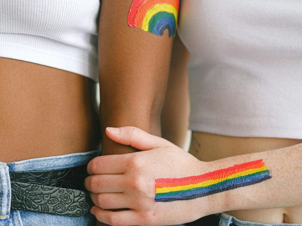 gay couple with rainbow paint holding hands