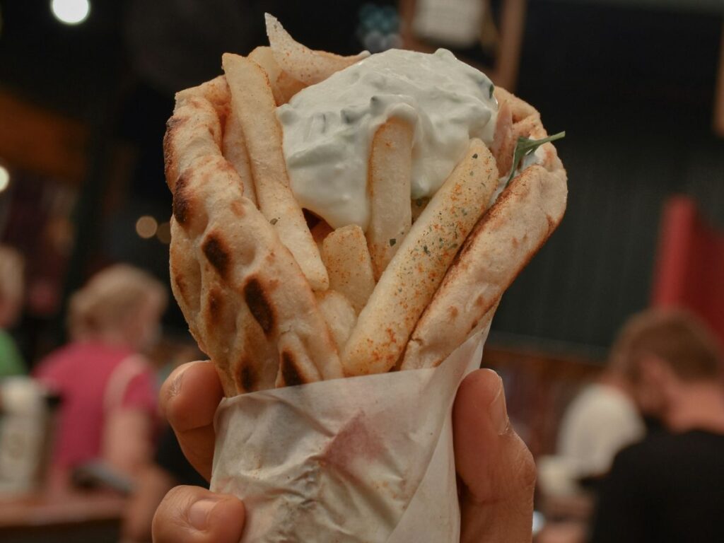 holding a gyro in hand