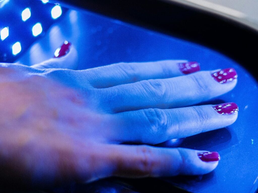 hands under UV light after nail treatment 