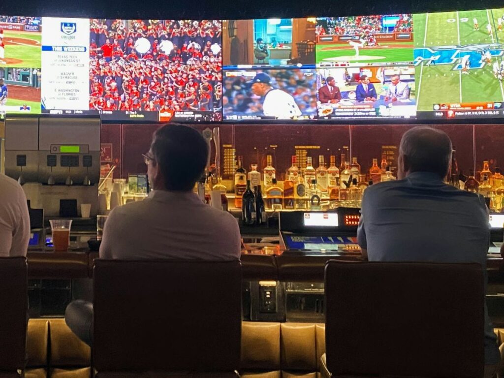 men drinking and watching game in a sports bar