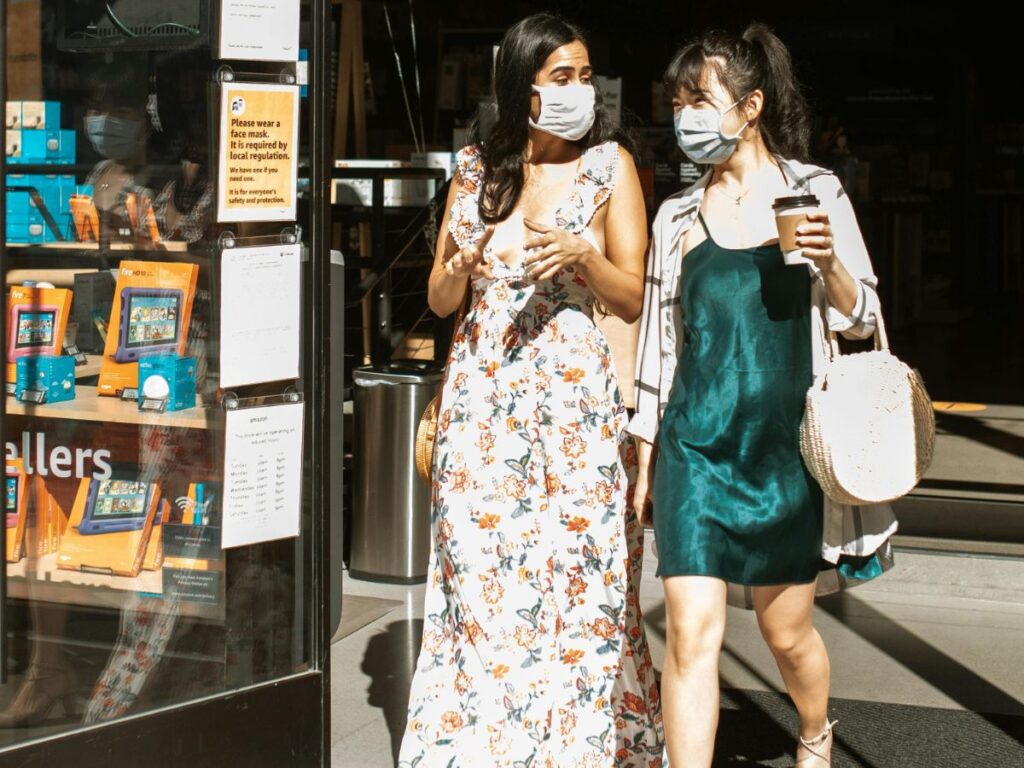 women wearing dresses coming out of a shop