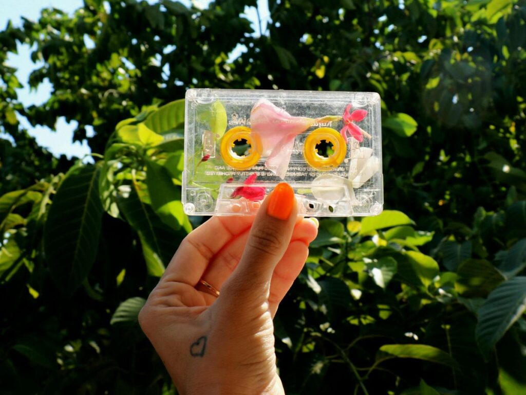holding musical cassette in a park