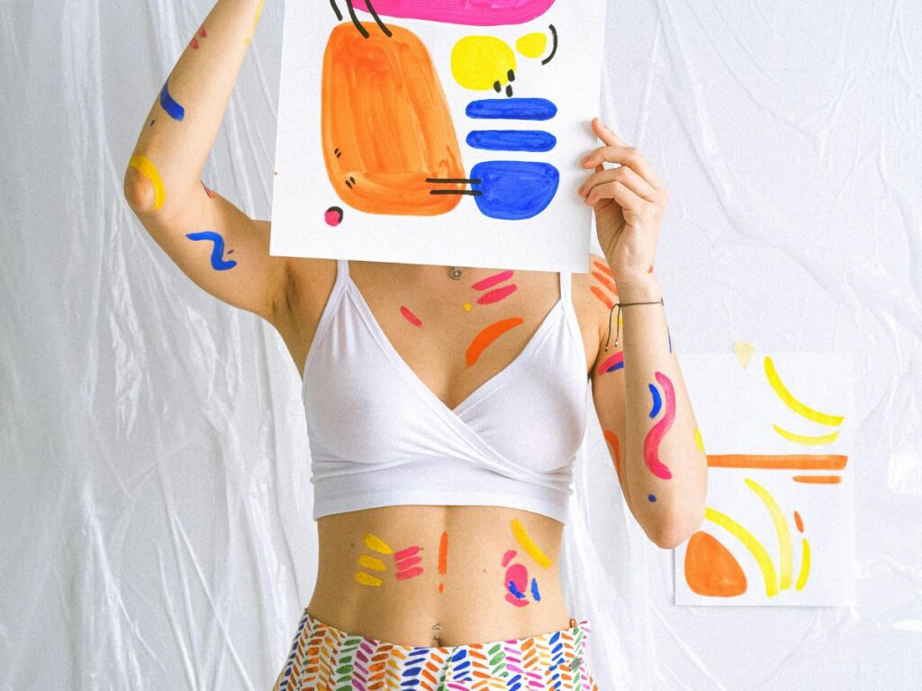 woman holding a painting after painting it