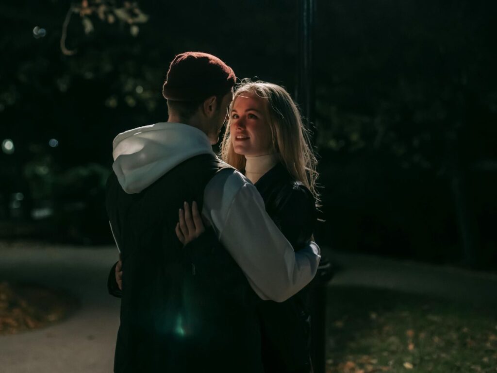 couple hugging each other in park