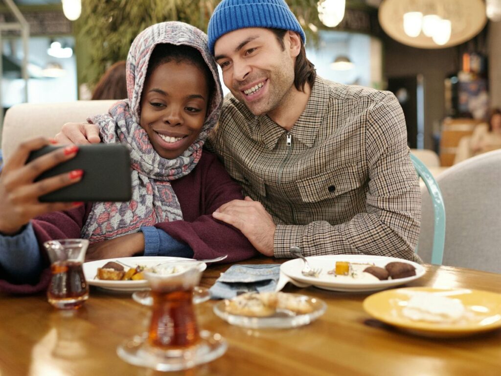 couple sitting in a restaurant taking selfie