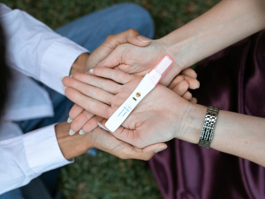 couple holding a pregnancy test strip