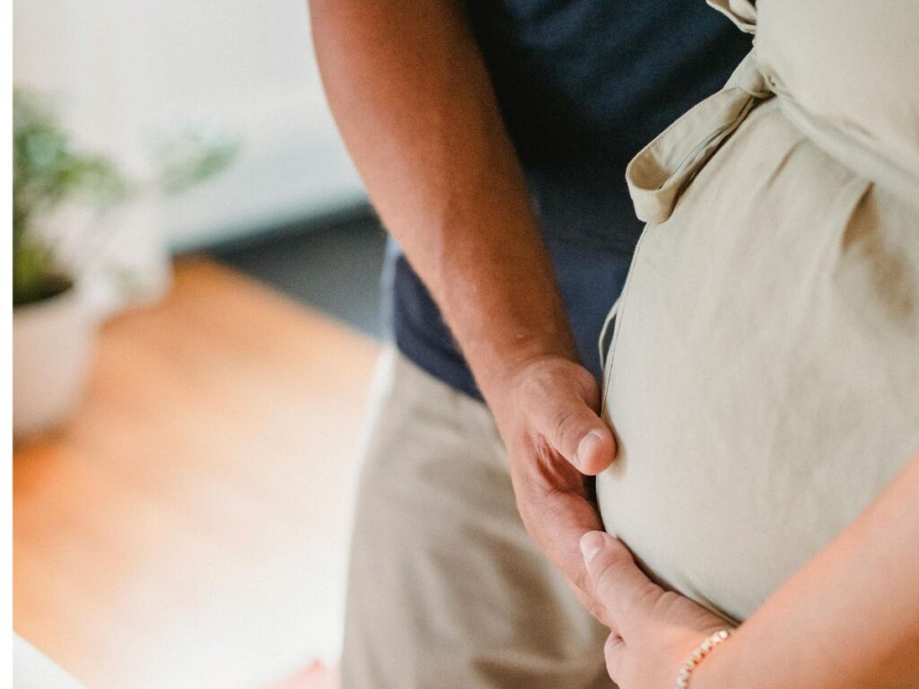 man holding a pregnant woman's belly