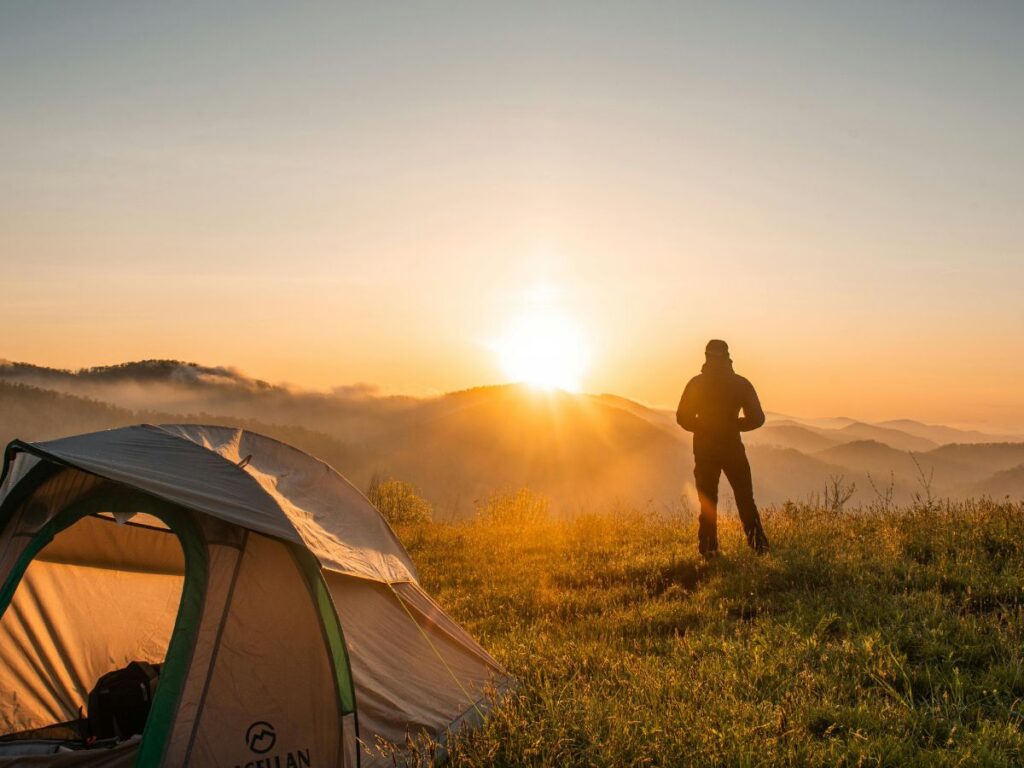 man watching sunset while camping