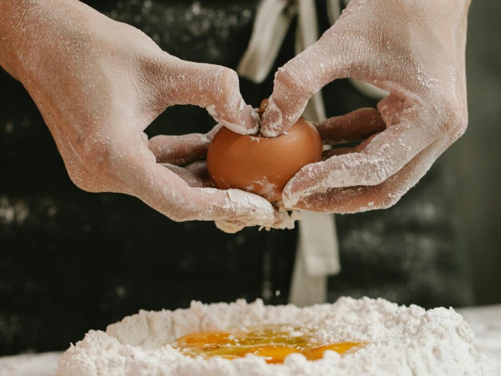 breaking eggs into flour