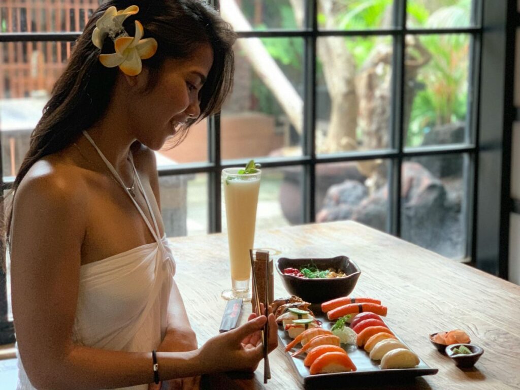 woman eating sushi in a restaurant