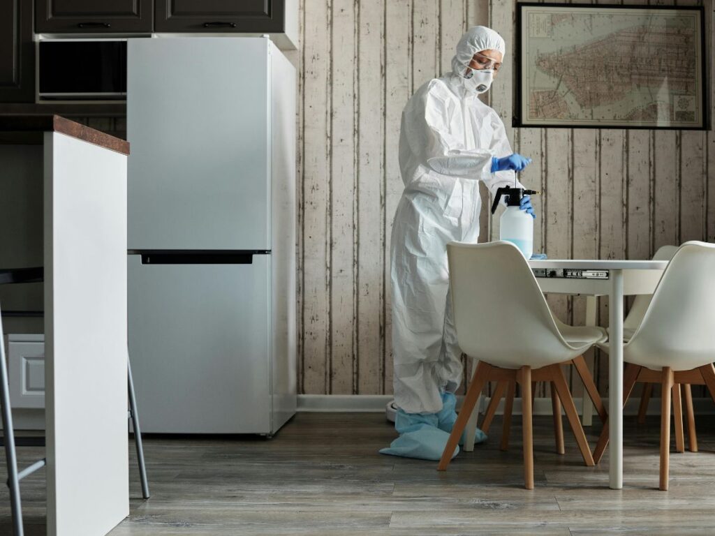 cleaner wearing PPE and cleaning