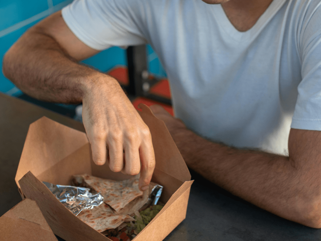 man eating in food court