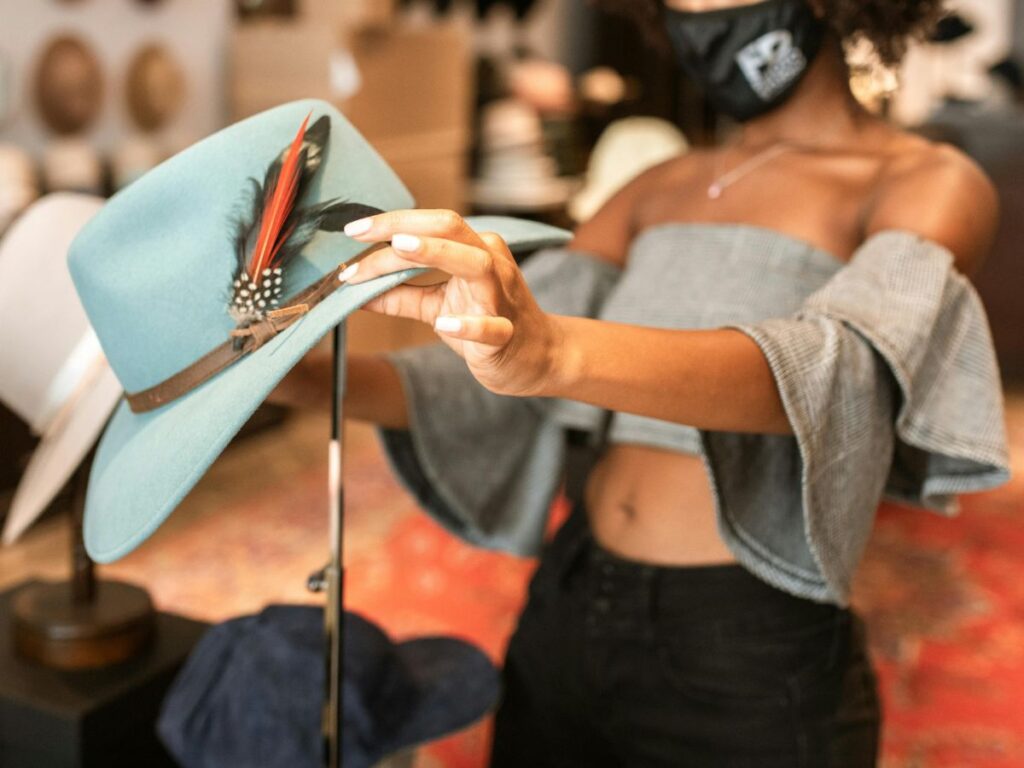 woman checking a hat in a hat store