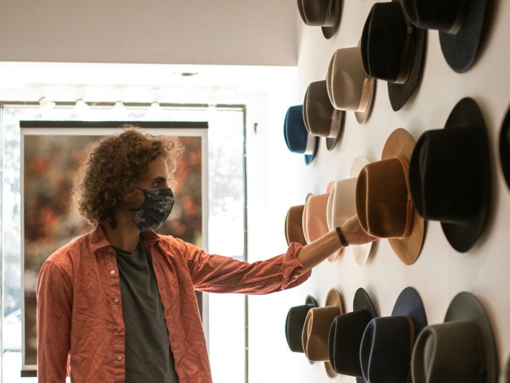 man checking hats in a hat store