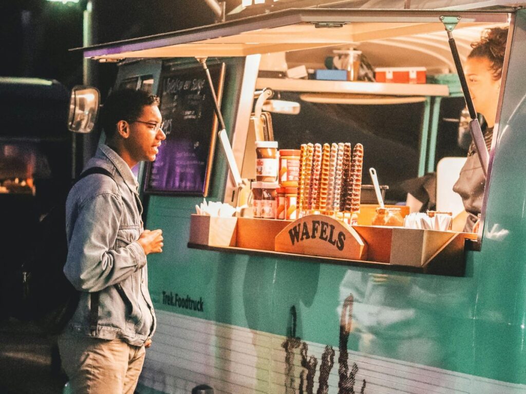 man buying waffles from street food truck