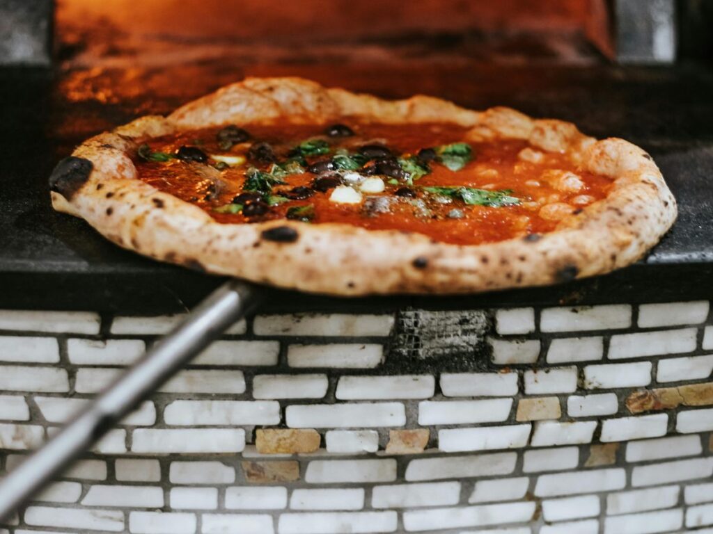 putting Neapolitan pizza in oven 