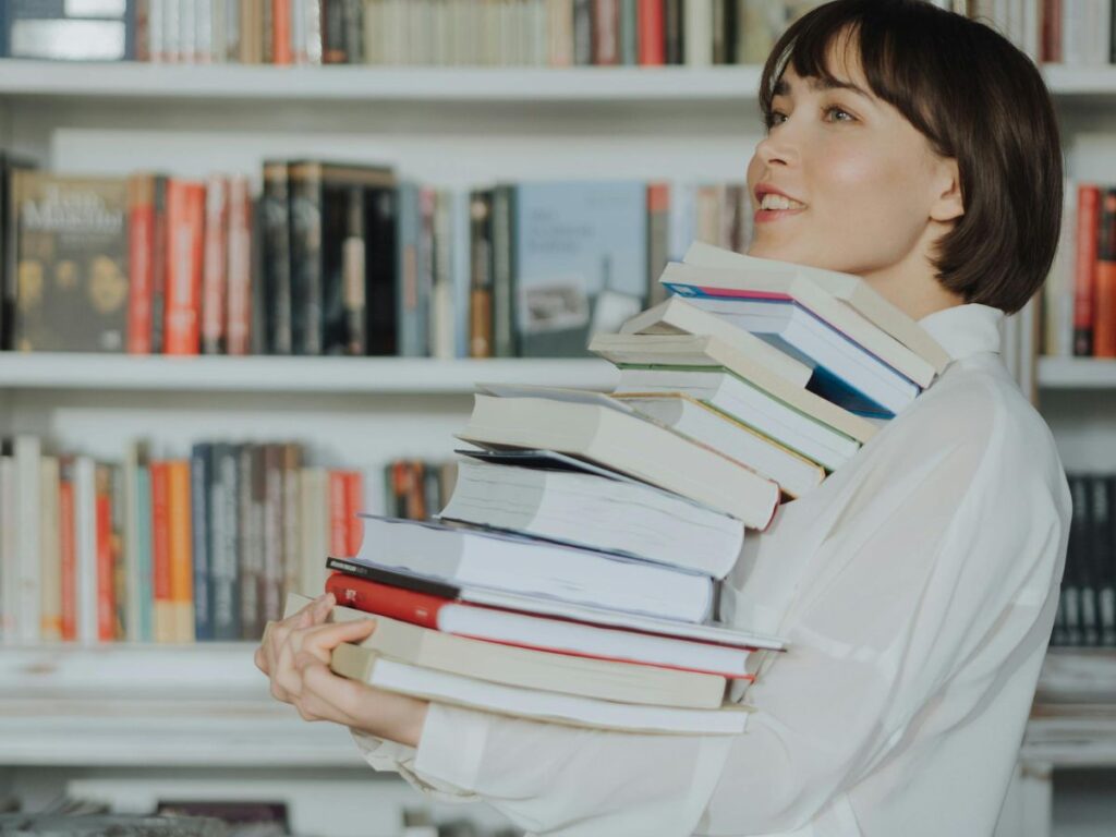 woman carrying many books