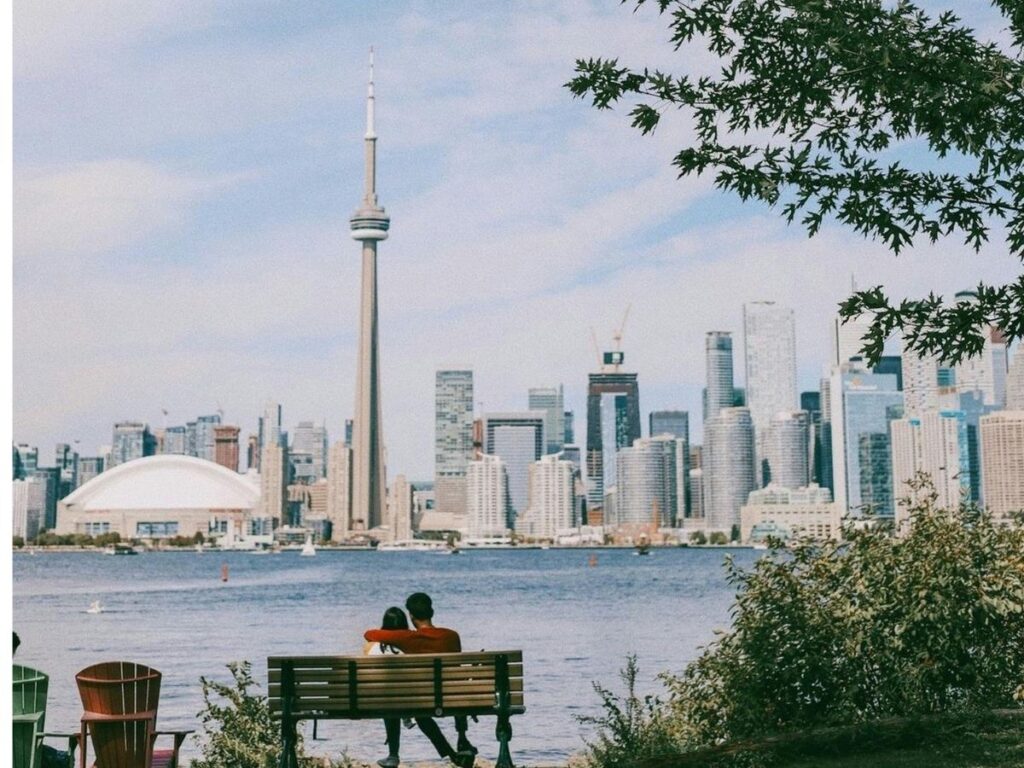 couple sitting on bench in Toronto Islands Park