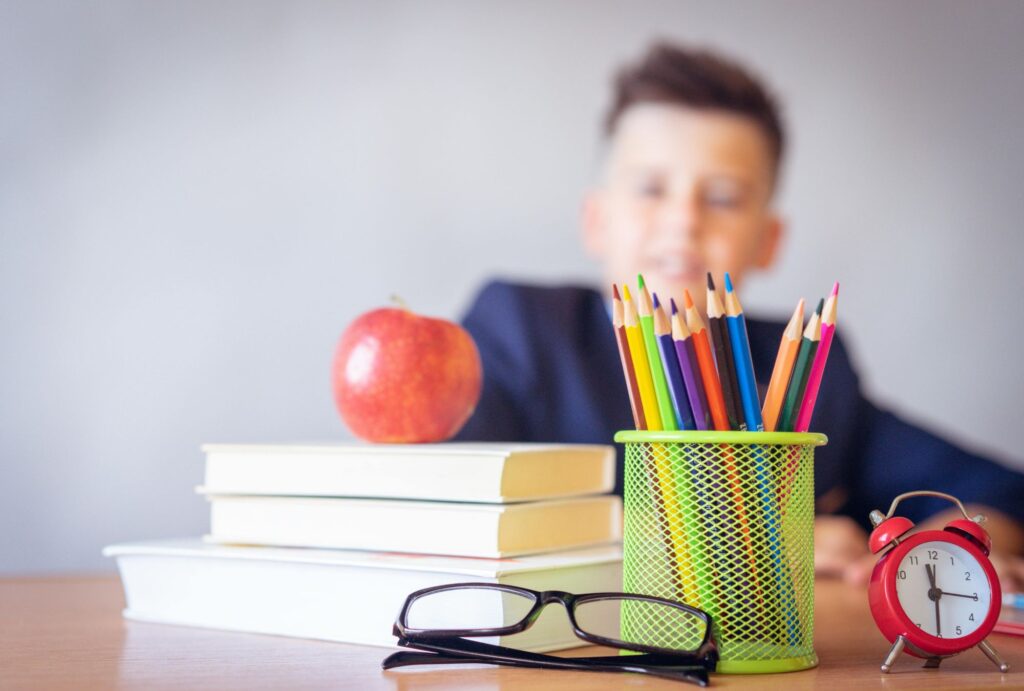 kid in school with books and stationery