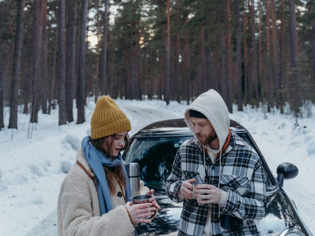 couple having coffee in winter in woods